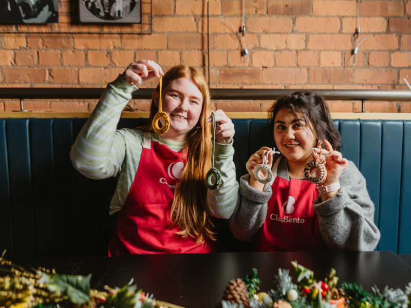 Women showing off handmade macrame decorations